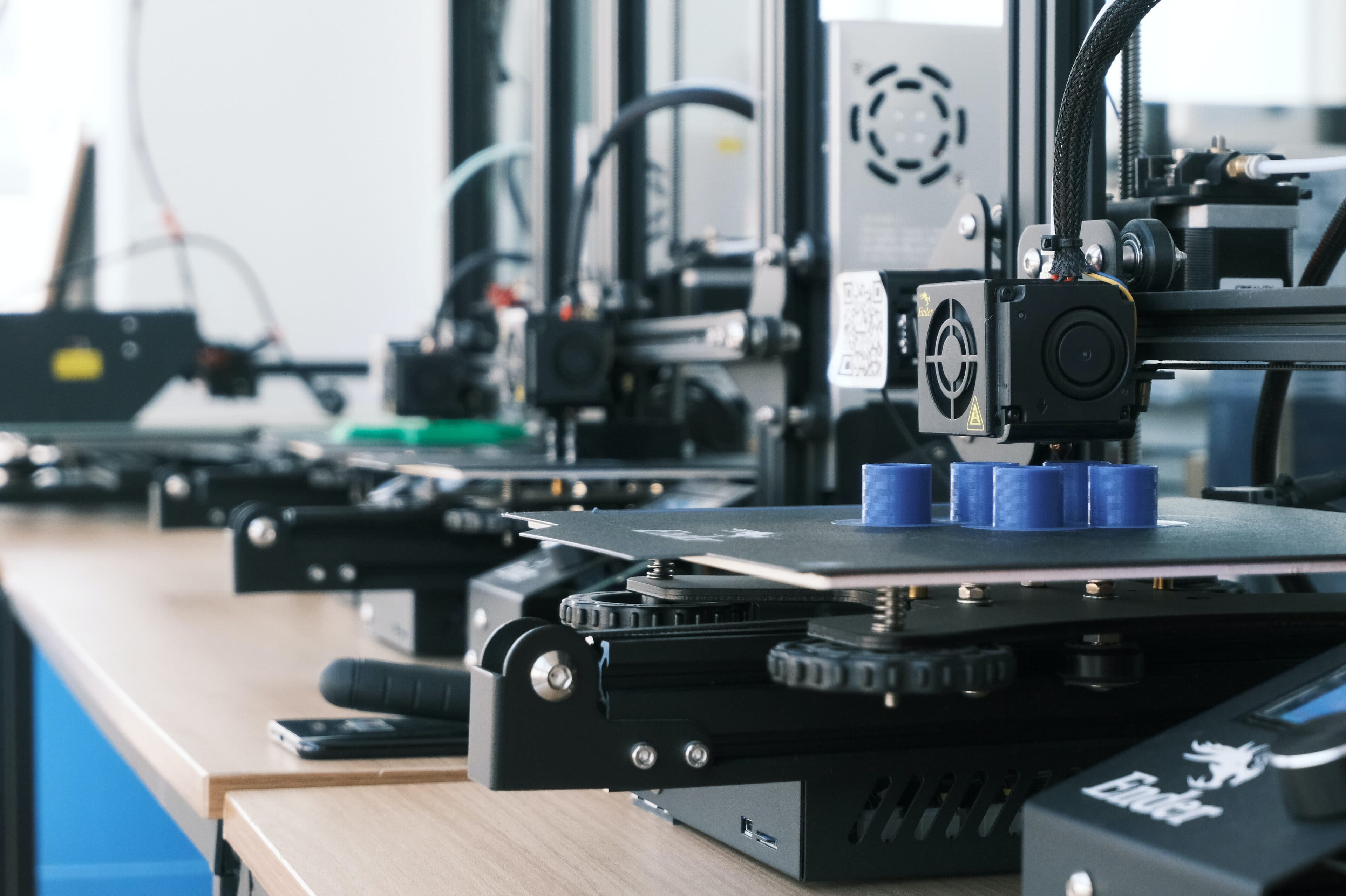 Rows of 3D printers printing blue parts